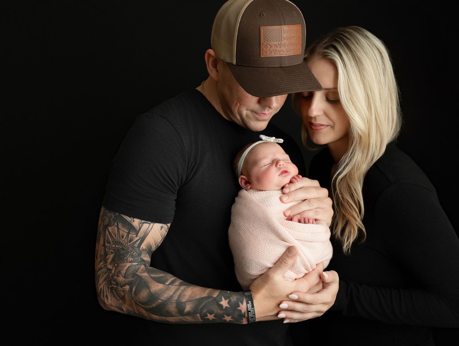 Mom and dad is holding the newborn baby girl very tenderly.  - Greenville SC newborn photographer - Easley SC newborn photographer