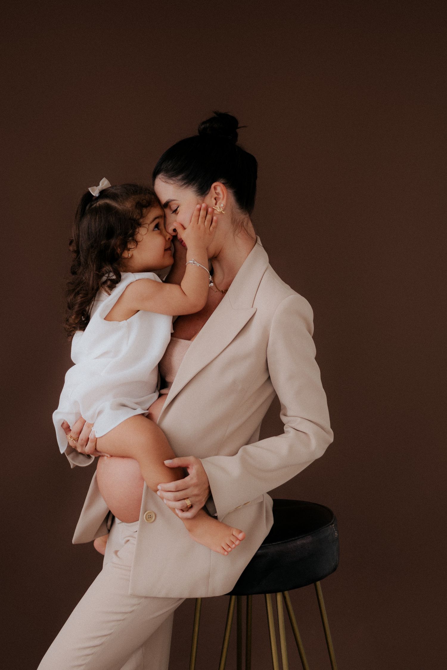 Intimate moment shared between parent and child against dark backdrop.