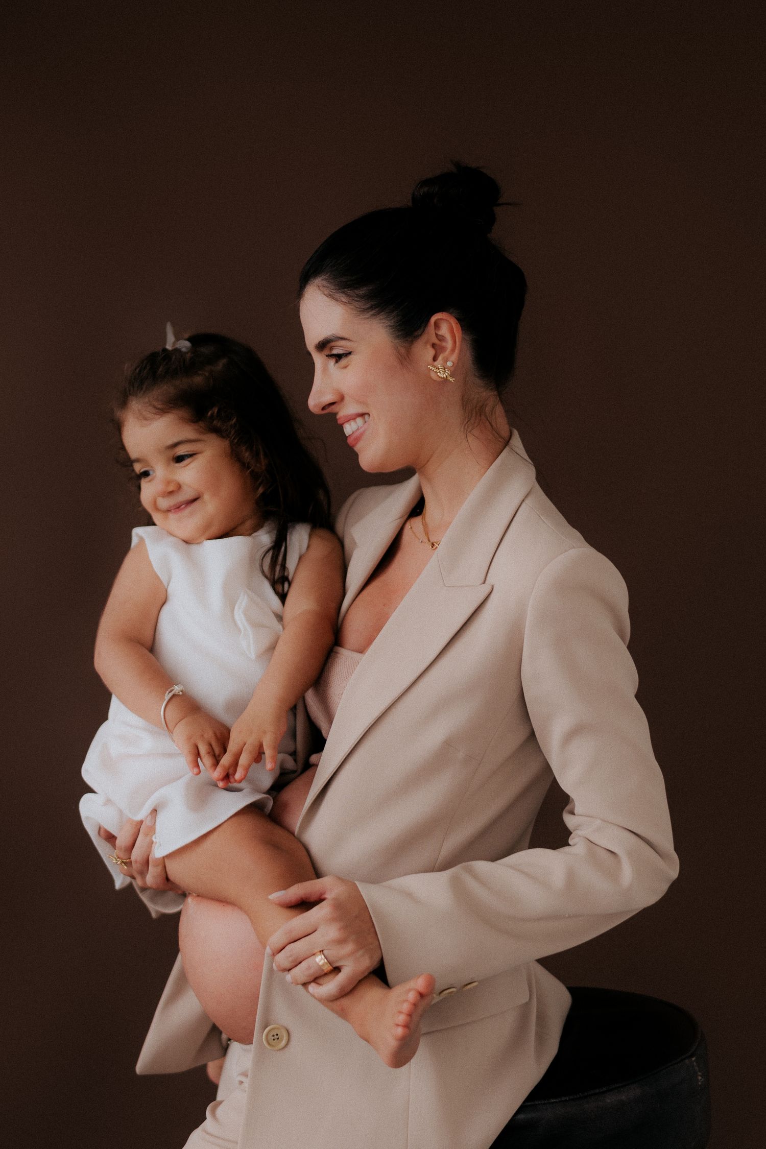Sweet candid moment captured between parent and child in formal attire.