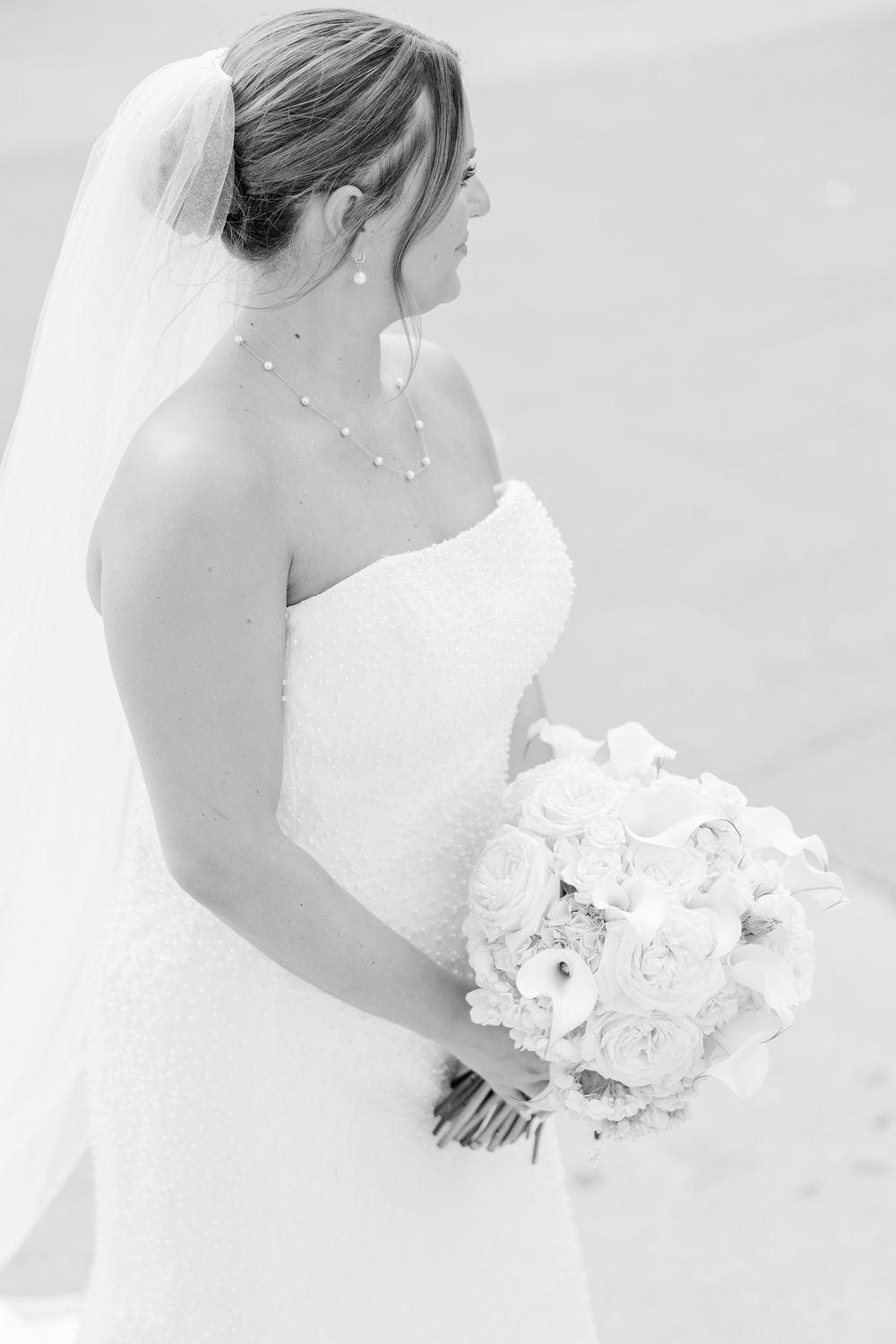 A bride in a white wedding dress holds a bouquet of white roses in an ethereal sequence of romantic portraits.