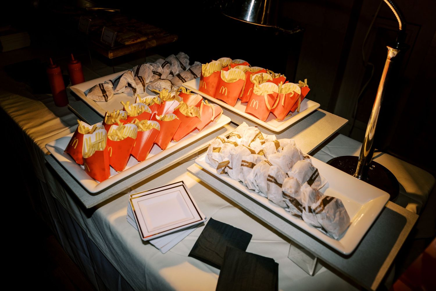 An assortment of fresh sushi rolls and sashimi displayed on serving platters at a restaurant buffet.