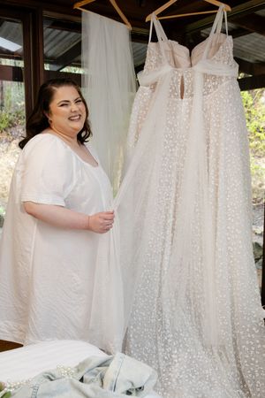 Bride getting ready for her wedding white lace wedding dresses hanging on display