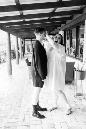 bride jokingly covering grooms face so he doesent see her before the ceremony. Candid wedding photography