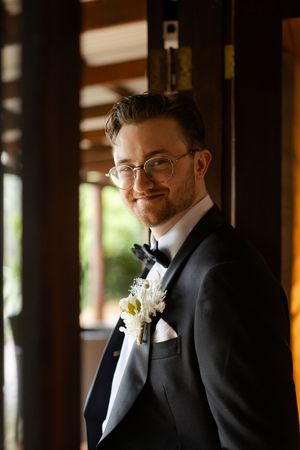 Candid portrait shots of groom in formal black tuxedo and bowtie.