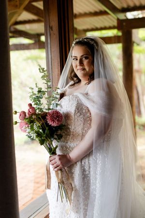 Wedding photos showing bridal dress details and pink flower bouquet in natural light.