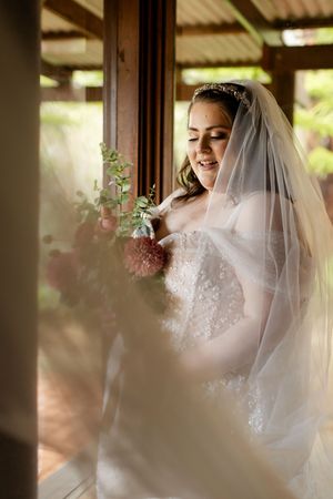 A bride in a white lace dress and veil glows with joy in a sequence of intimate getting-ready moments.