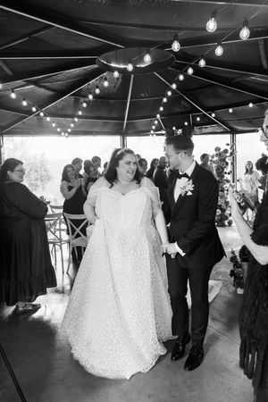 Black and white photo of groom and bride walking down the isle