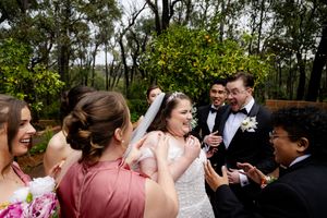 Wedding party members share joyful embraces congratulating the bride and groom after the ceremony
