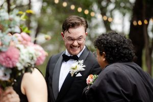 excited groom is congratulated by their wedding guests.