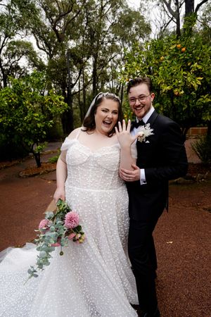 A happy couple shares joyful moments in an outdoor wooded setting during their wedding celebration.