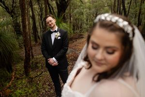 wedding portraits of couple in a wooded landscape, portrait of the groom with their bride in the foreground