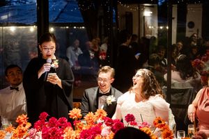 Elegant wedding reception dinner setting with colorful floral centerpieces and ambient lighting.