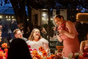 Evening wedding reception with string lights creating warm atmosphere as guests celebrate.