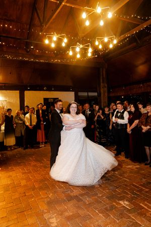groom twirls bride performing their first dance. Kirsten Graham wedding photography