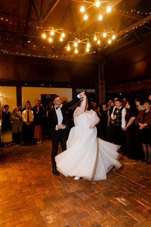 groom twirls bride performing their first dance. Kirsten Graham wedding photography