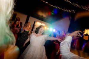 bride dancing at her wedding reception. Dance floor photography motion blur and colourful lighting effects.