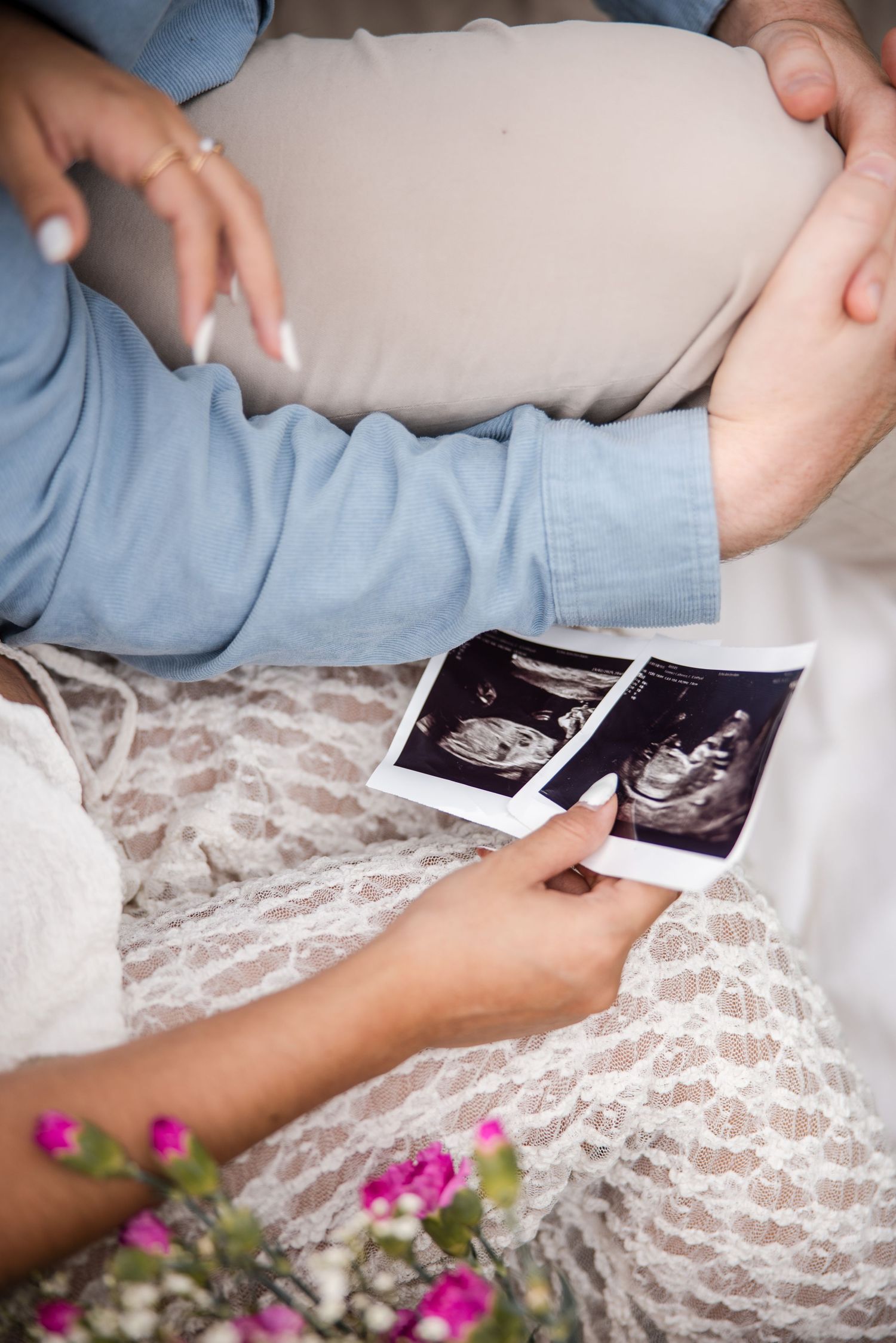 Closeup of hands holding two ultrasound photos