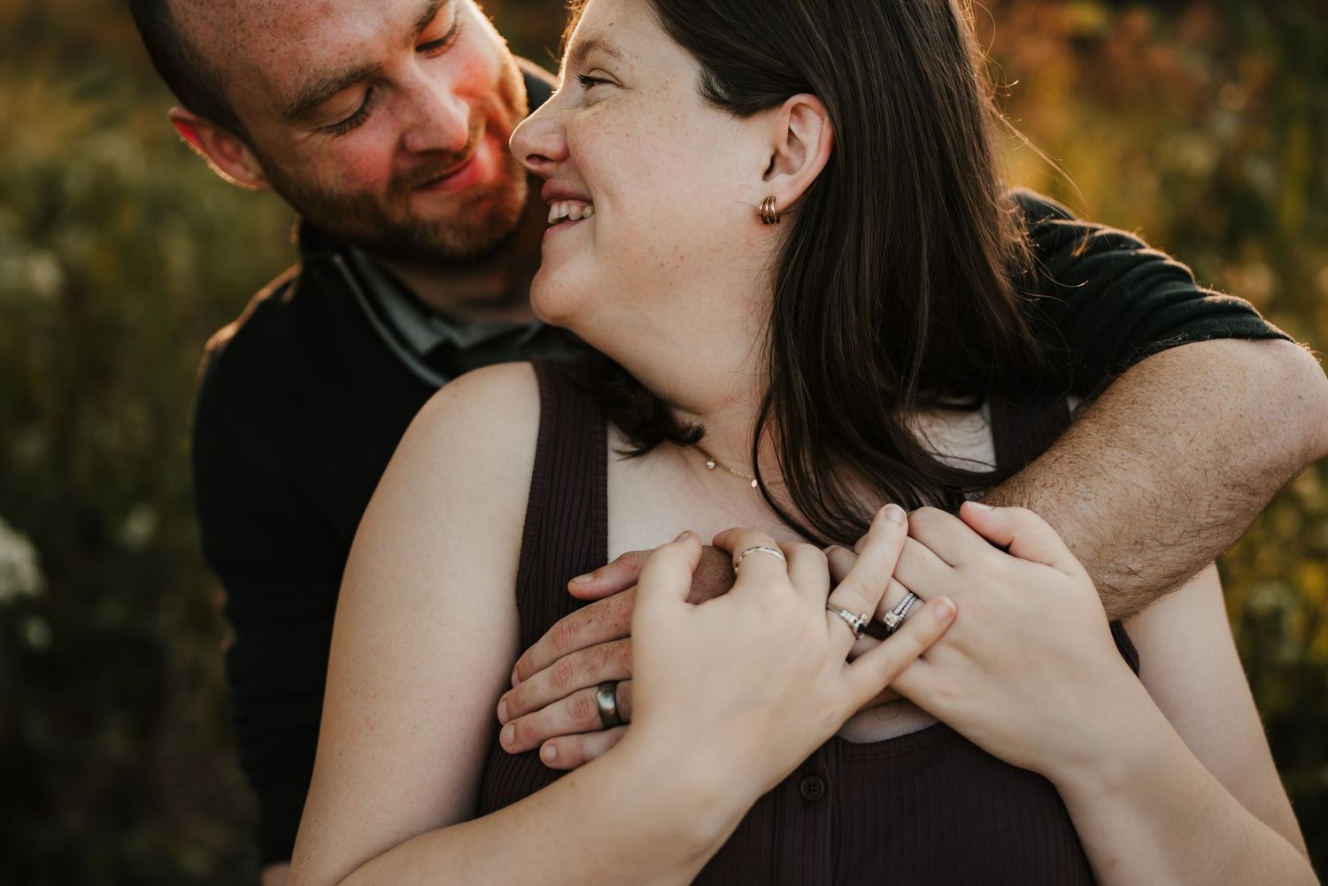 Pregnant mother smiling and holding her baby bump during a mini session.