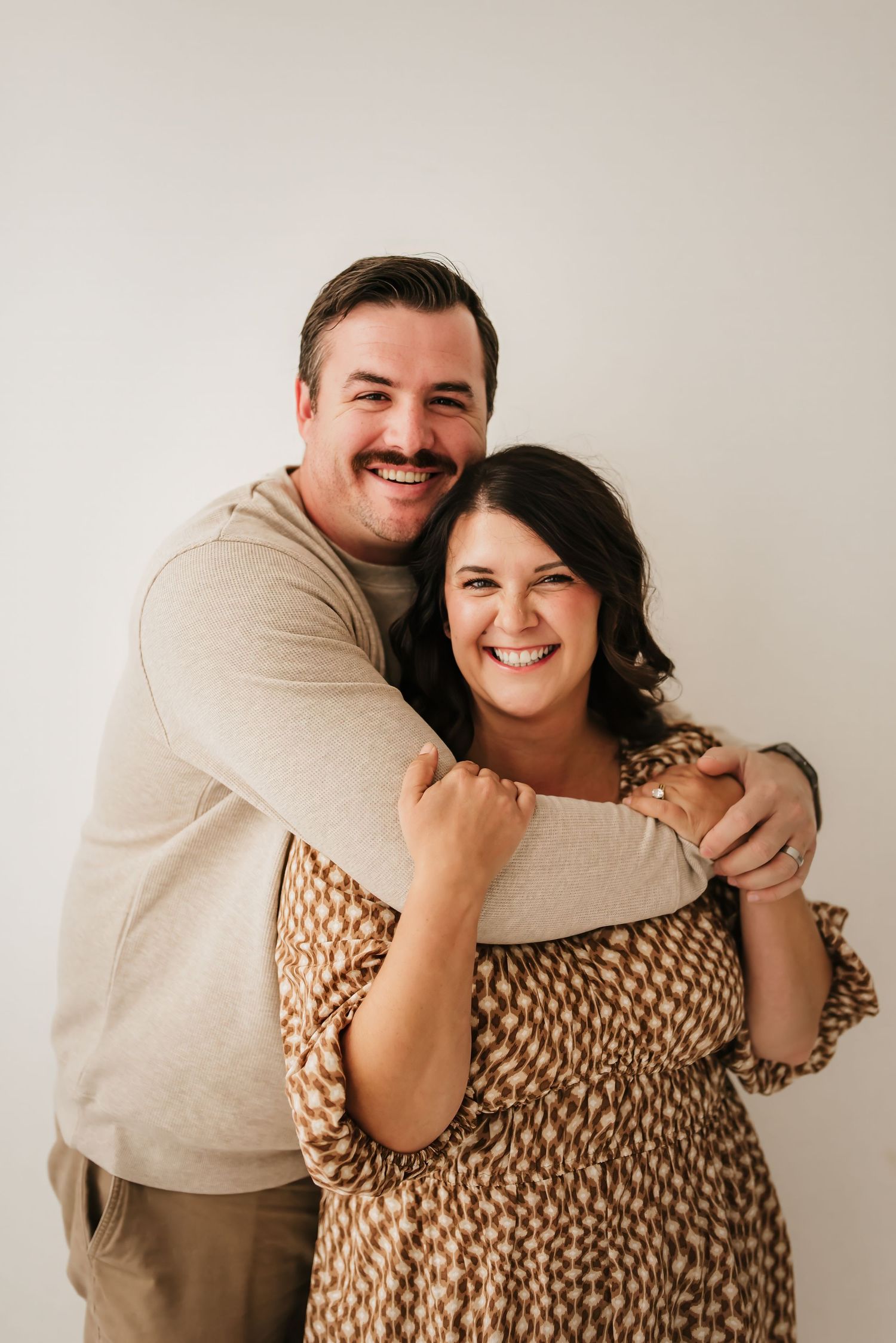 Family hugging and smiling for a candid mini session photo.