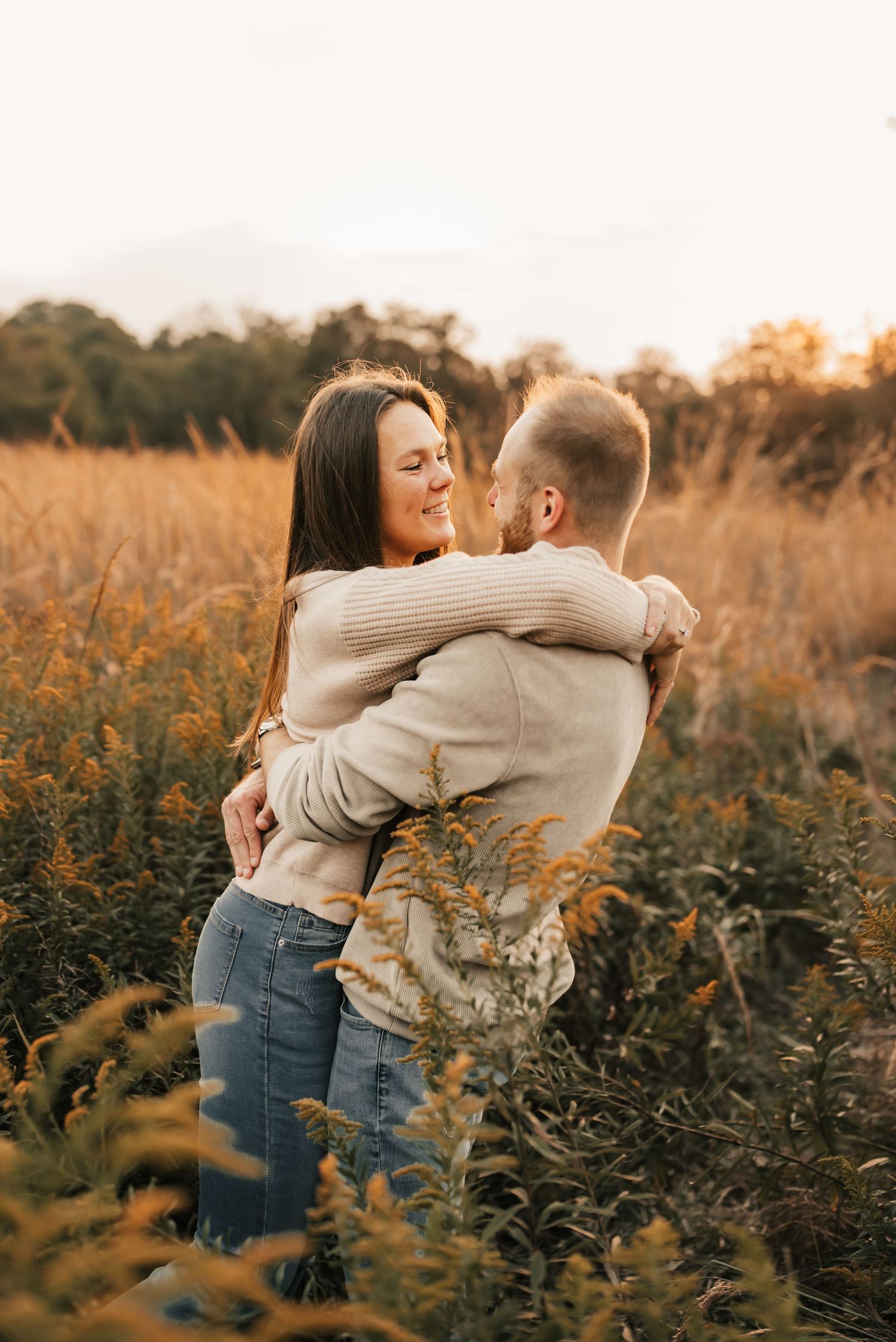Engaged couple holding hands and laughing during a mini session in the park.