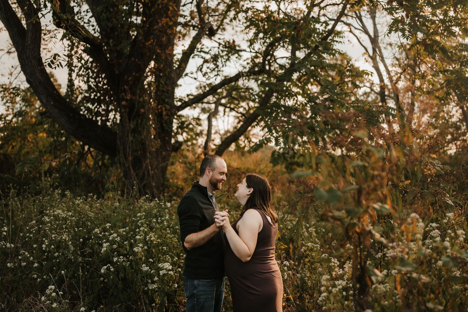 Pregnant mother smiling and holding her baby bump during a mini session.