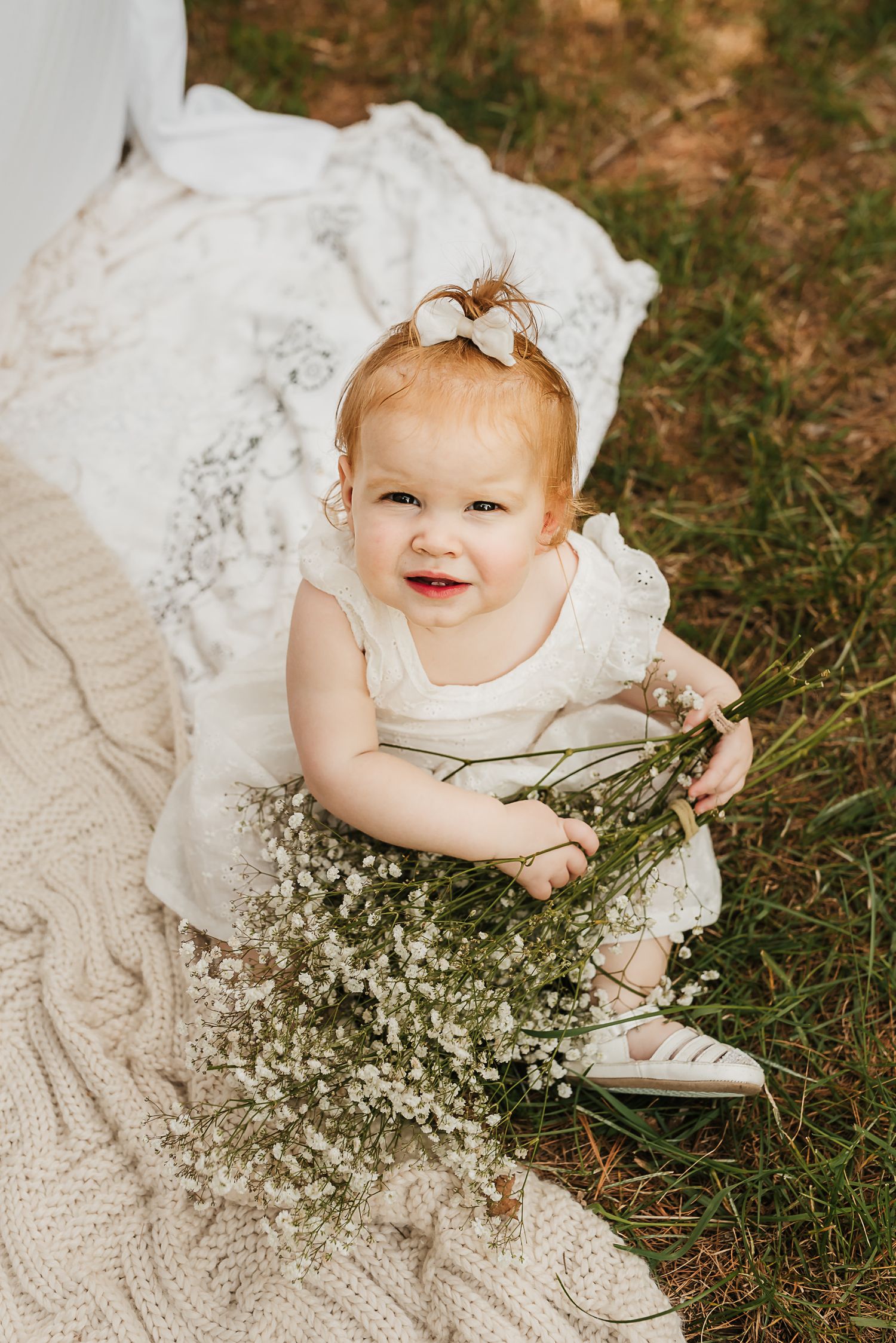 Mother and daughter holding hands in a field of spring flowers during a mini session.