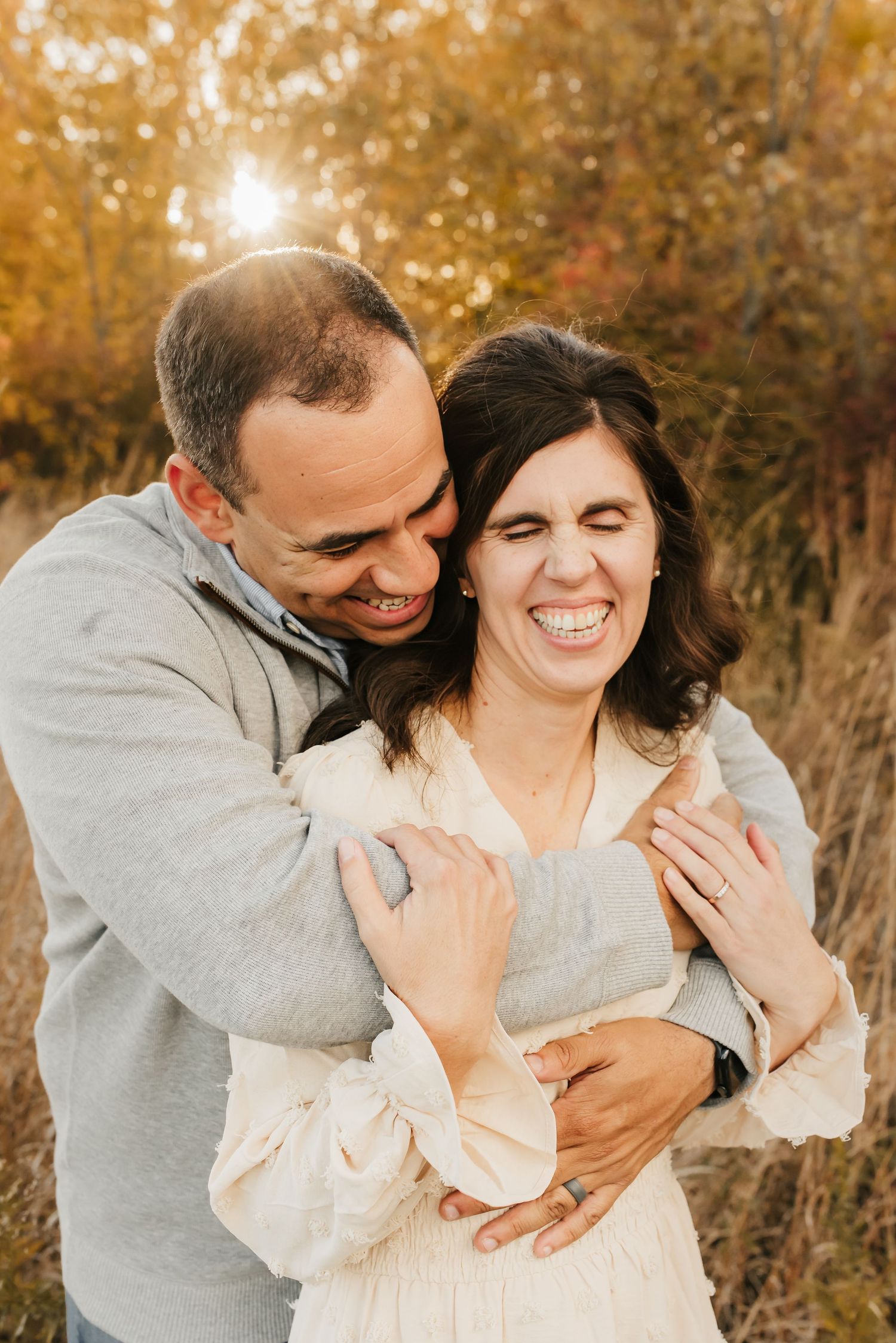 Family of seven laughing together during a fall mini session outdoors.