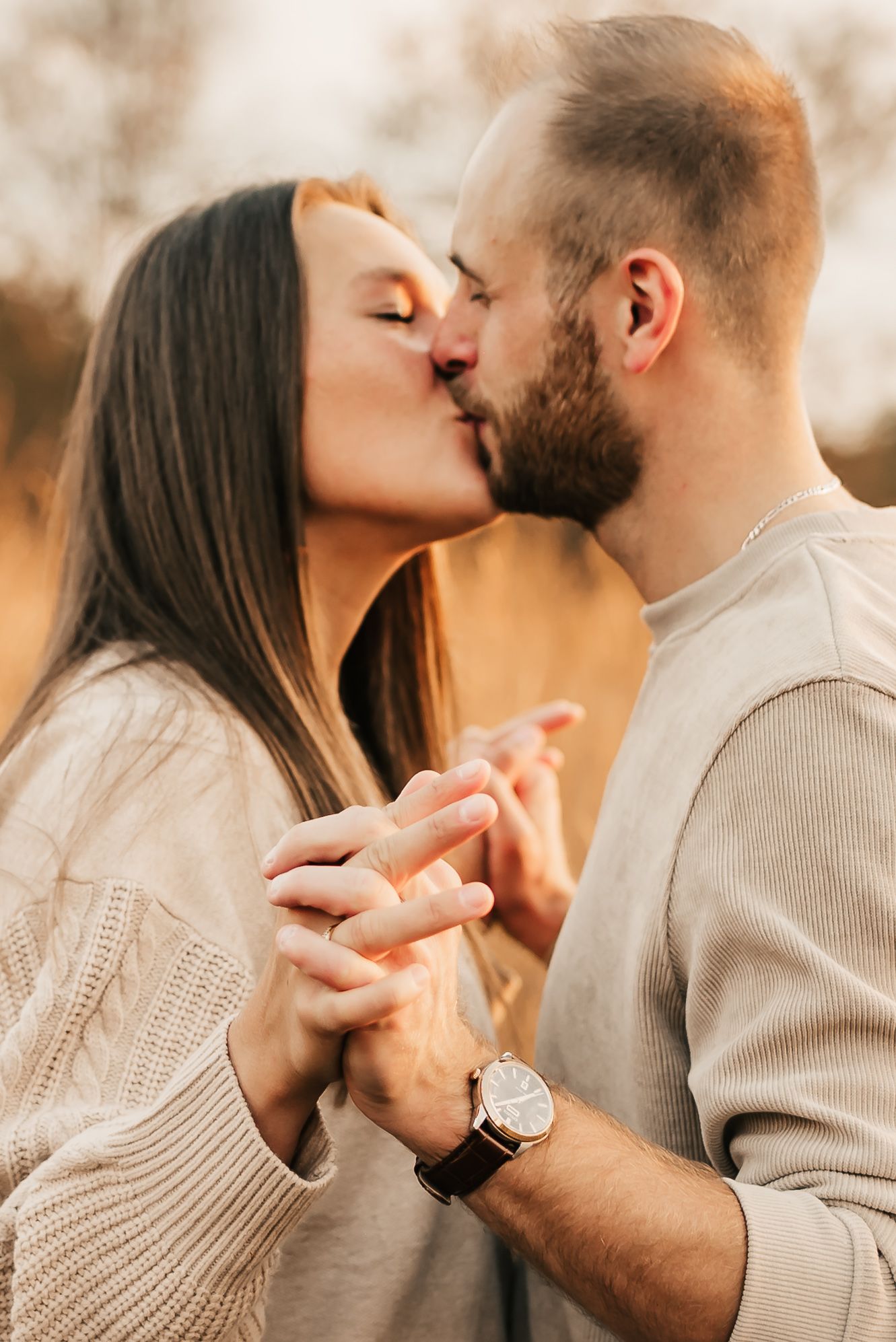 Engaged couple holding hands and laughing during a mini session in the park.