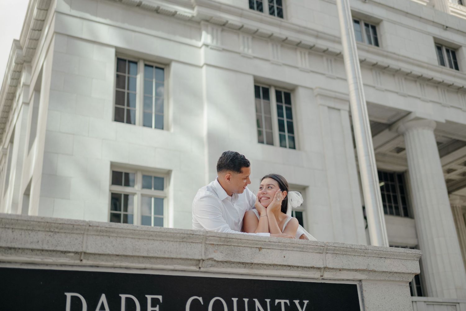 A white historic building facade with columns and windows stretches across the frame in an architectural view.