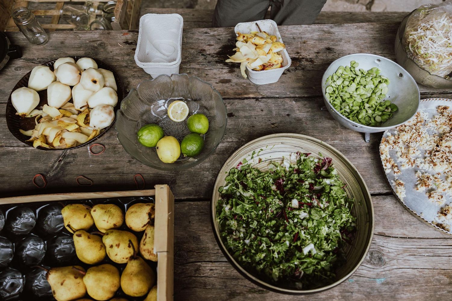 Fresh ingredients including potatoes, herbs, and citrus arranged on a rustic wooden table for meal preparation.