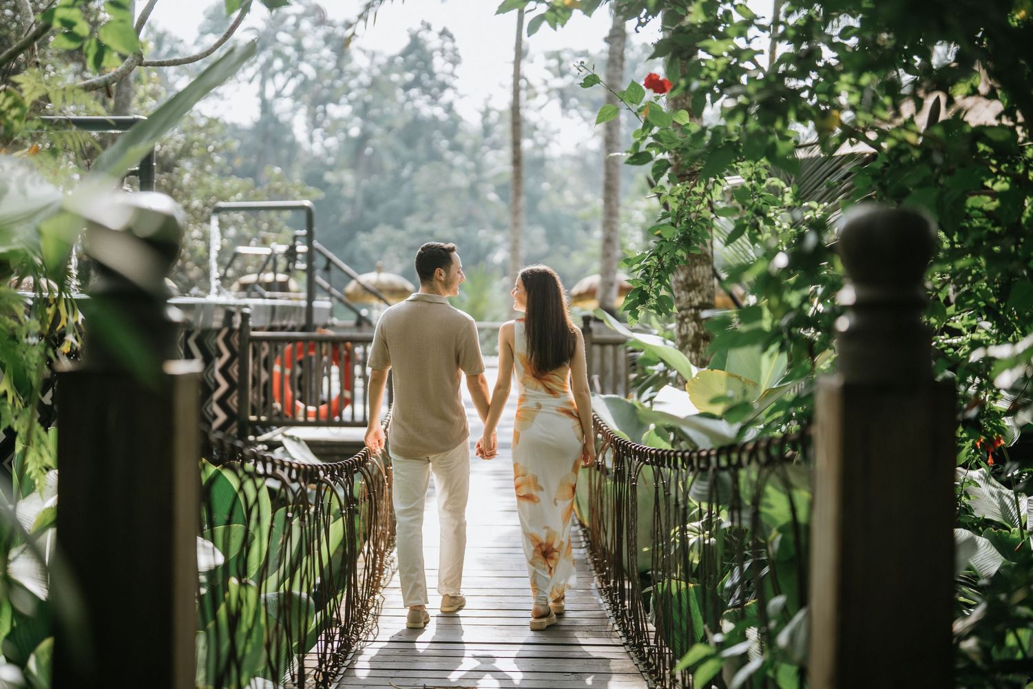 Family walking along a tropical garden pathway with their dog.