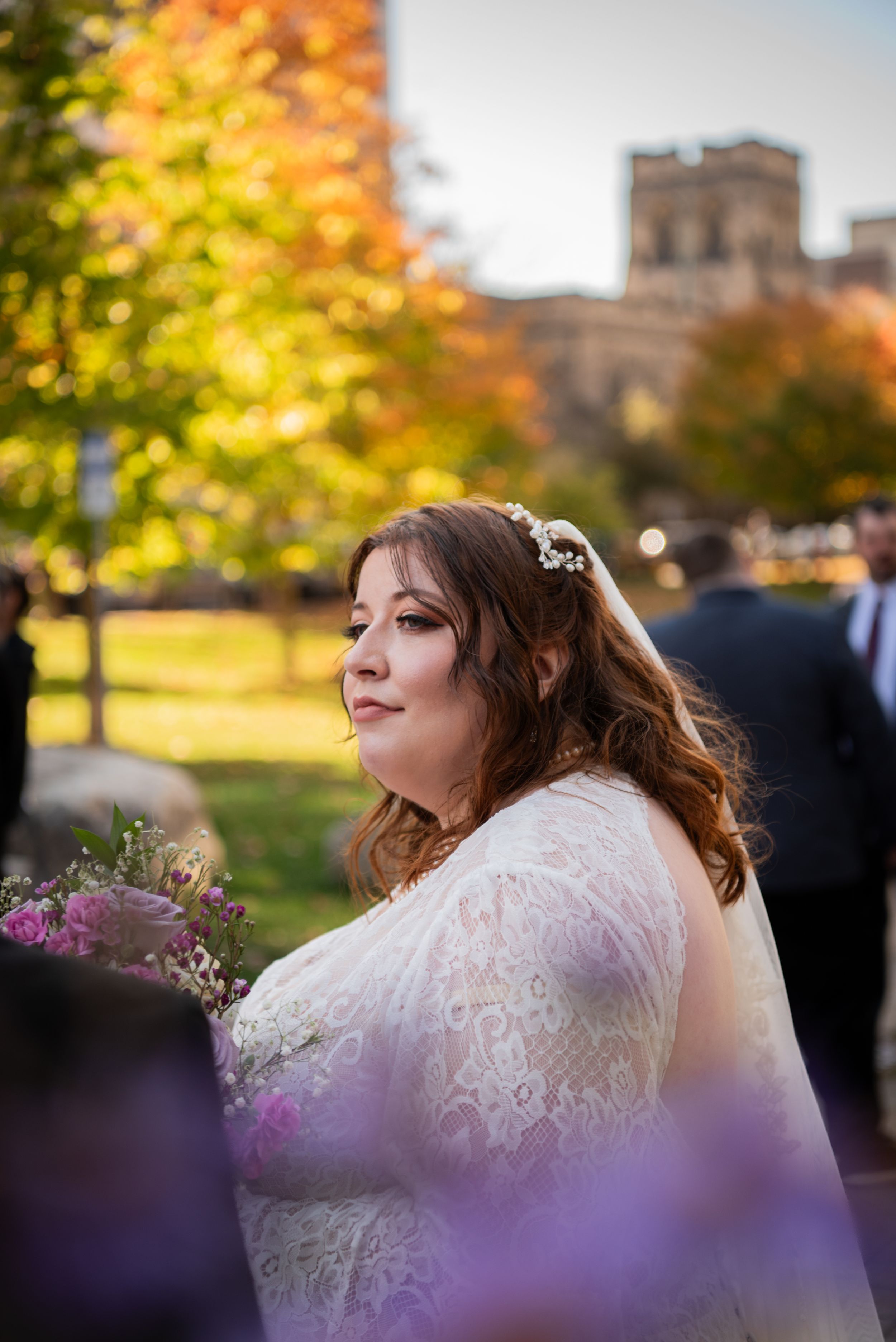 Autumn wedding scene with golden foliage and church architecture in the background.
