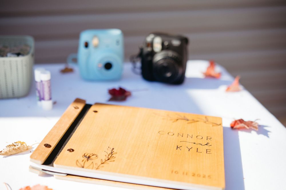 guest book sits on a table with polaroid cameras at an outdoor fall wedding, Bouctouche New Brunswick wedding photographer
