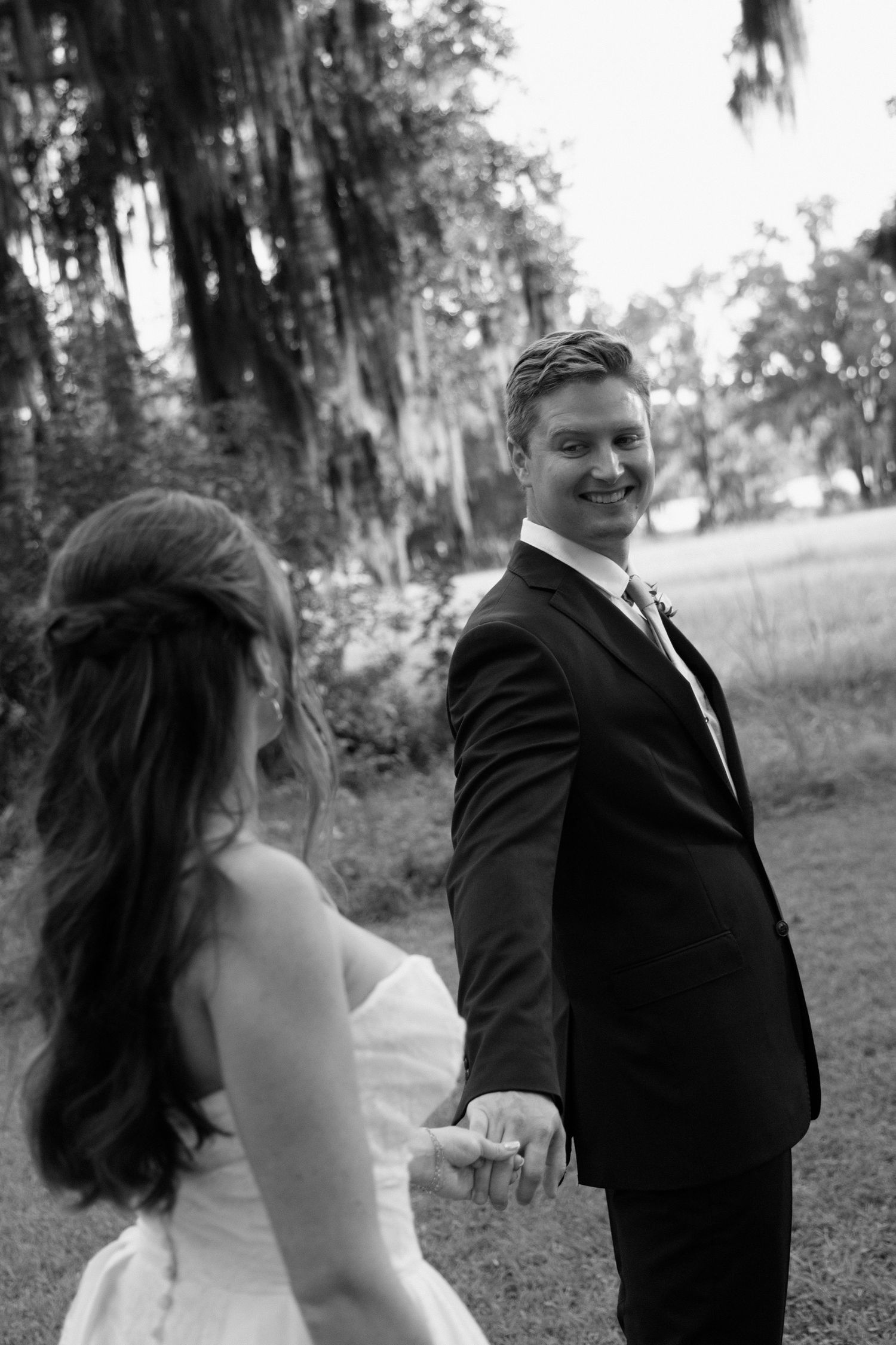 Black and white wedding photo series showing a romantic moment between a couple in formal attire outdoors.