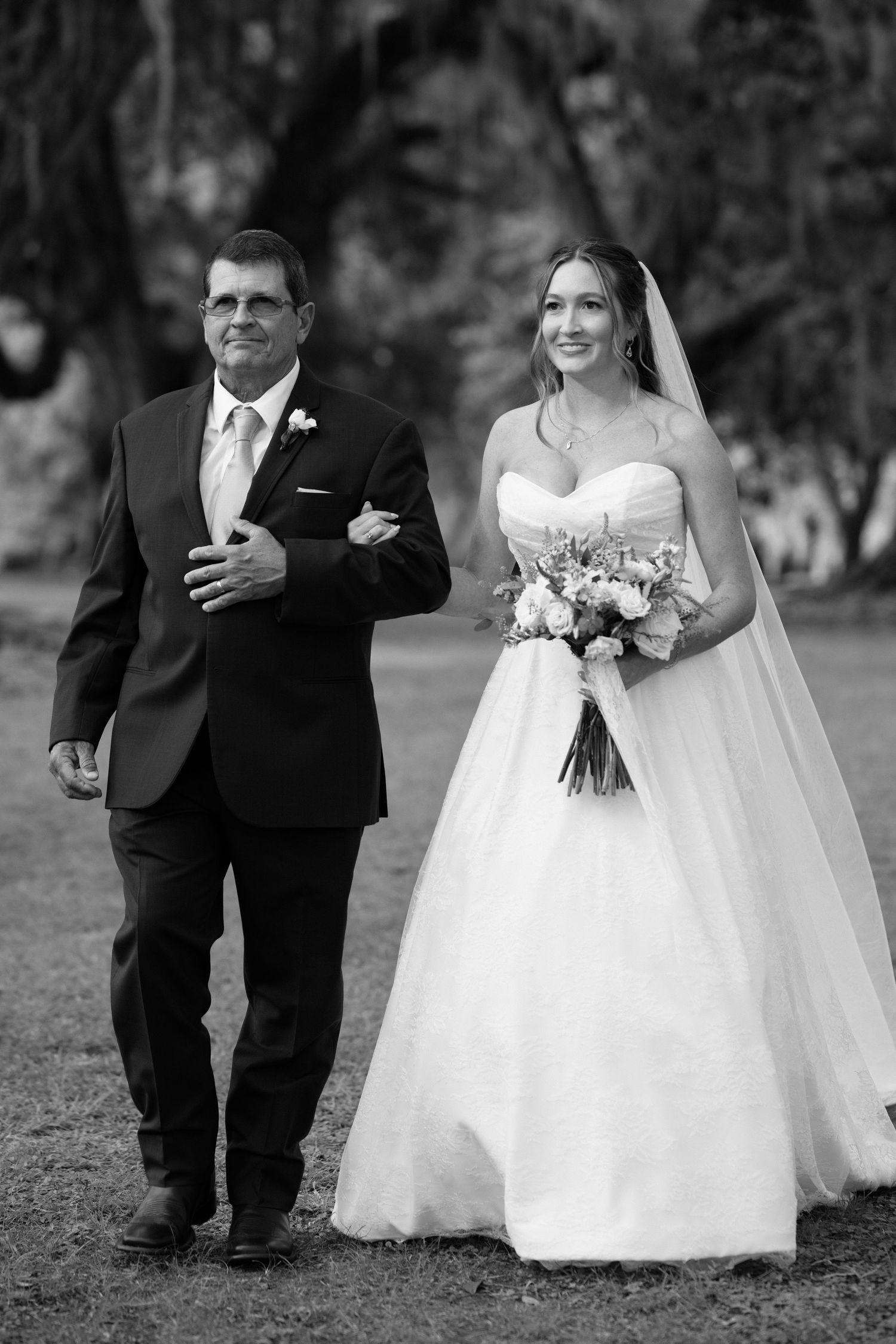 A wedding couple in formal attire walks together outdoors in a series of black and white progression photos.