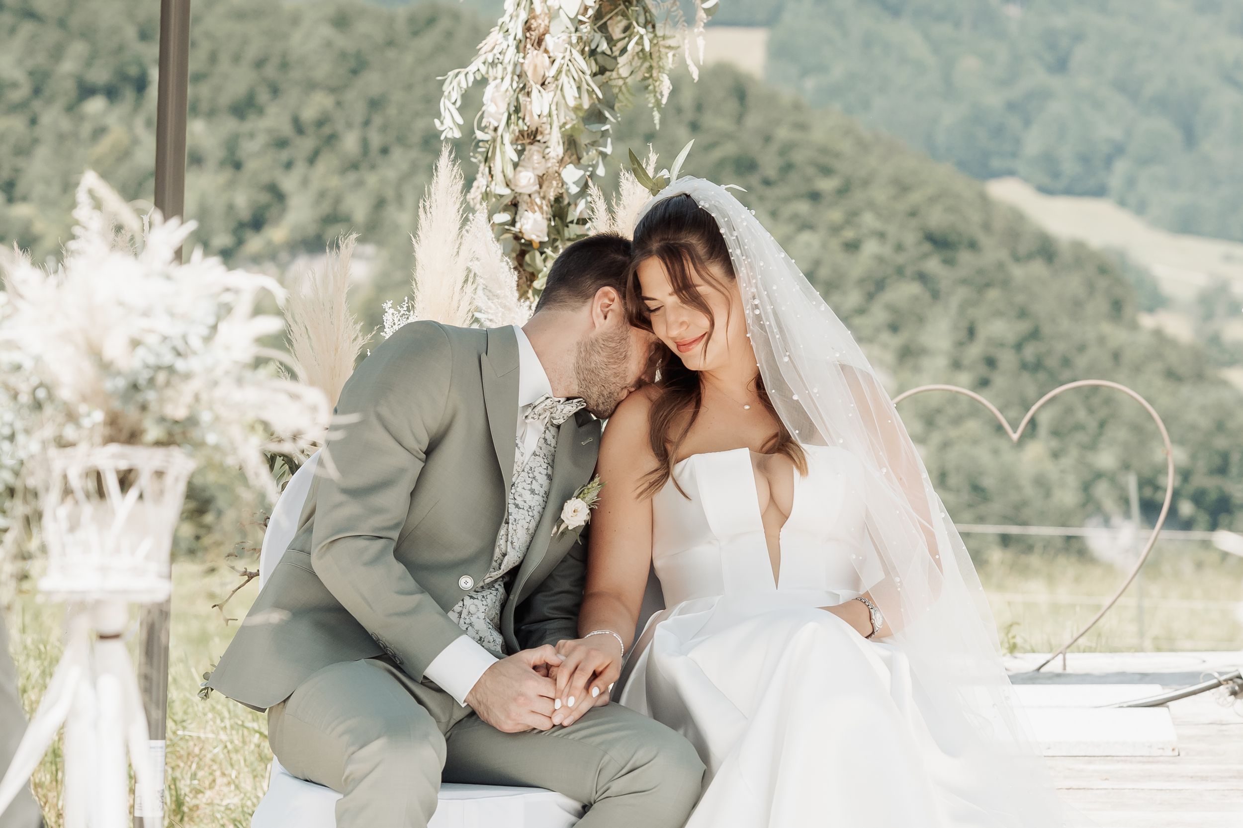 Intimate wedding moment captured in black and white against natural scenery.