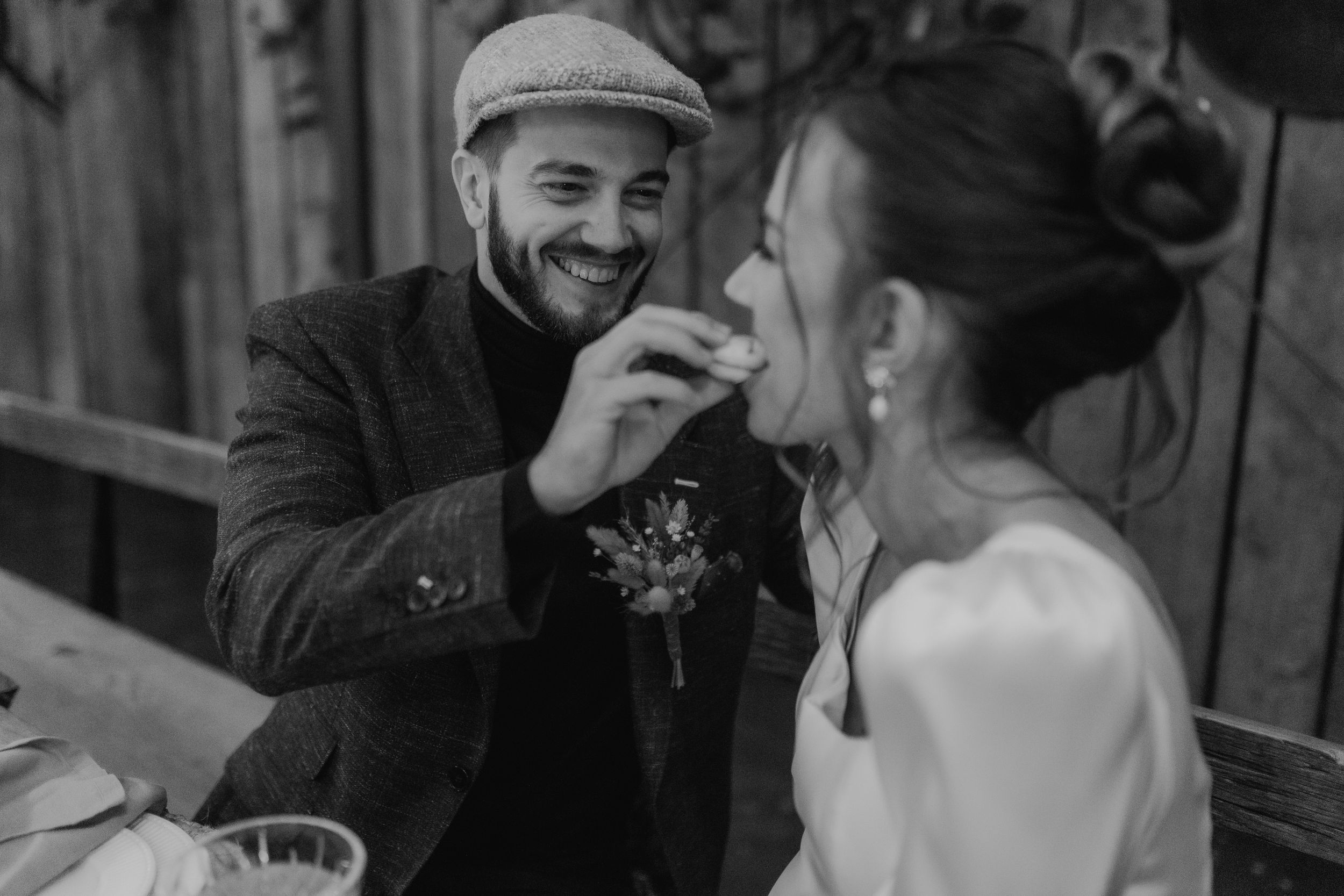 Candid black and white wedding photography showing tender moments between couple.