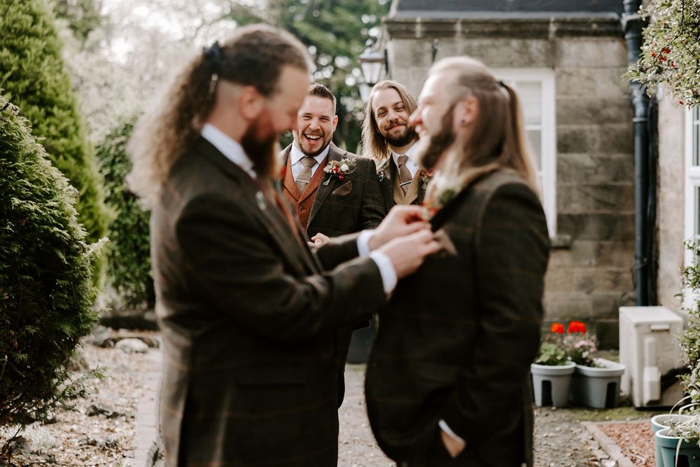 A couple shares a romantic moment during their wedding ceremony at a stone church in autumn.