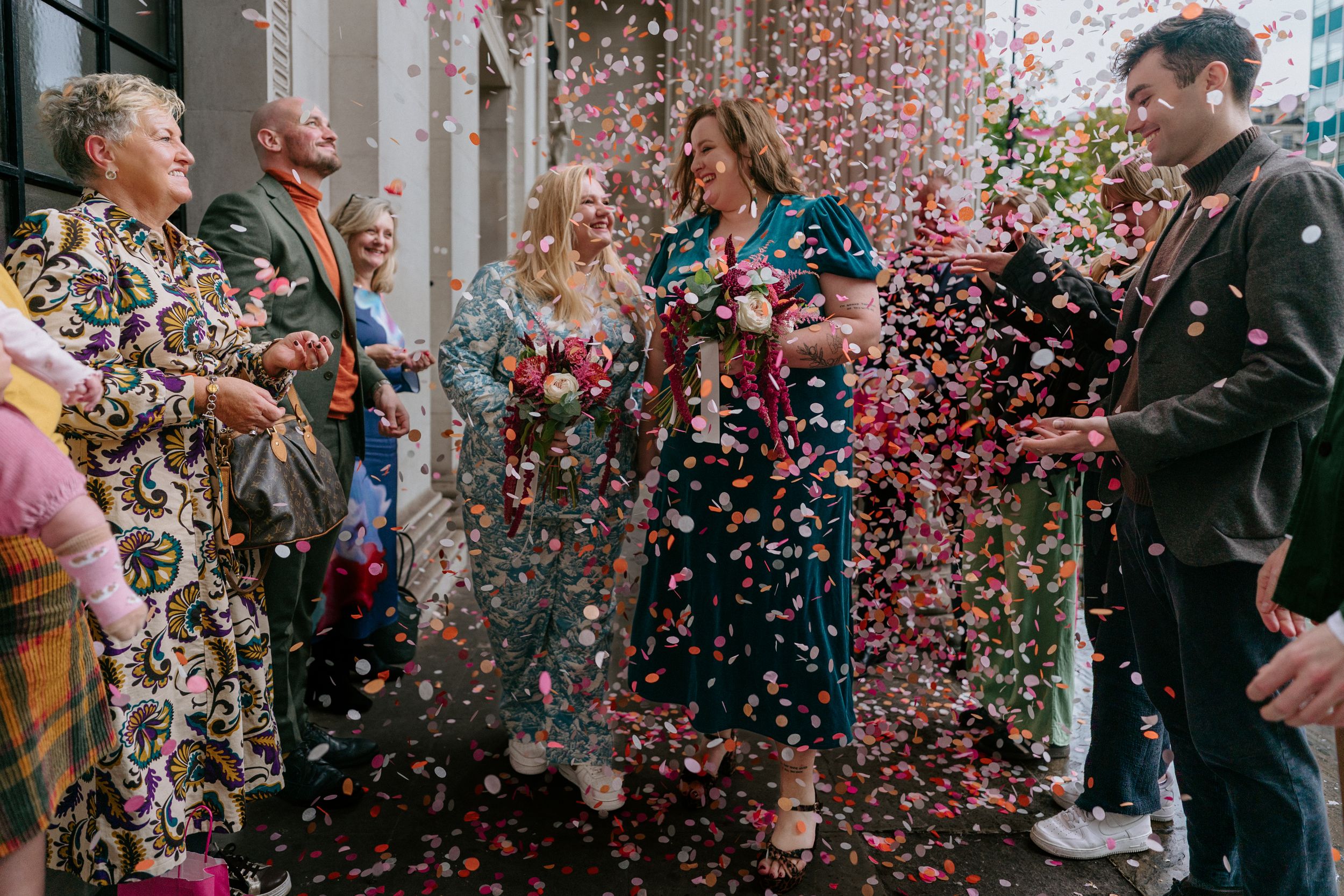 People celebrate with colorful confetti raining down during a joyous indoor event.