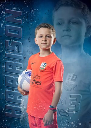 Young footballer posing in team strip, Llangefni Dragons U8's, North Wales.