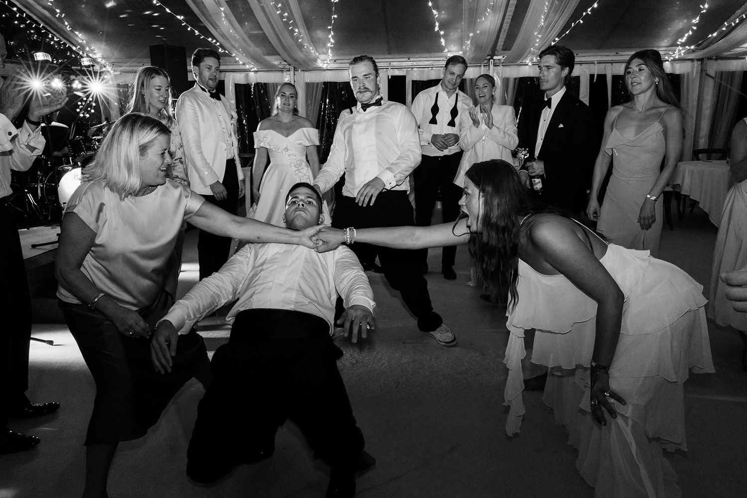 Wedding guests dance together on the dance floor during an energetic reception celebration.