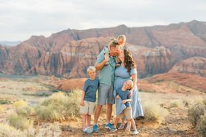 Desert landscape family photography session with red cliffs and natural vegetation.