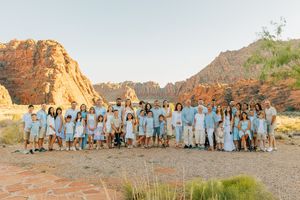 Large family group photo session with desert mountains and blue sky in the background.