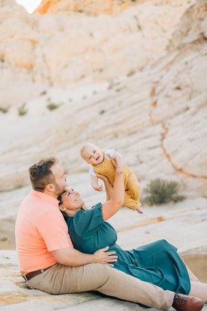 Couple relaxes on white rock formation while sharing playful moment together.