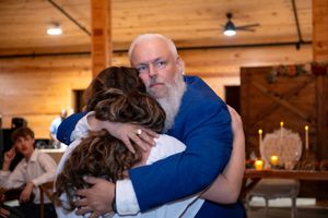 Dad and bride/daughter hug while dancing.