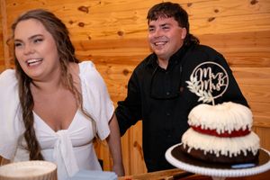 Wedding reception dessert table featuring decorated chocolate and white cakes.