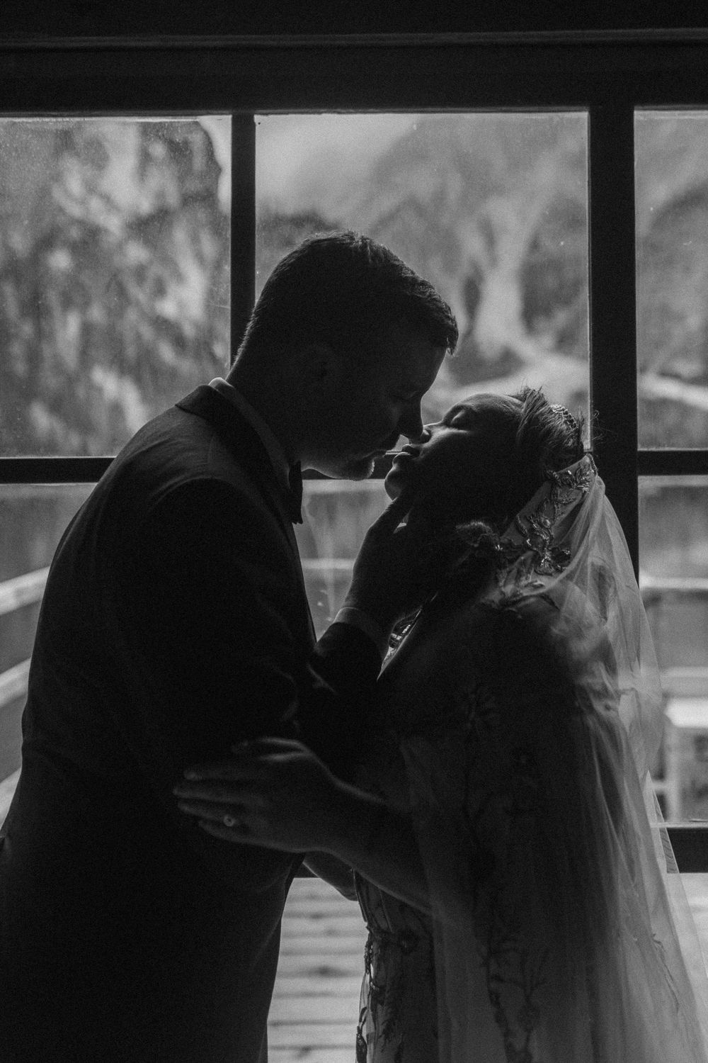 A series of black and white silhouettes show a couple in wedding attire sharing romantic moments in front of a window.