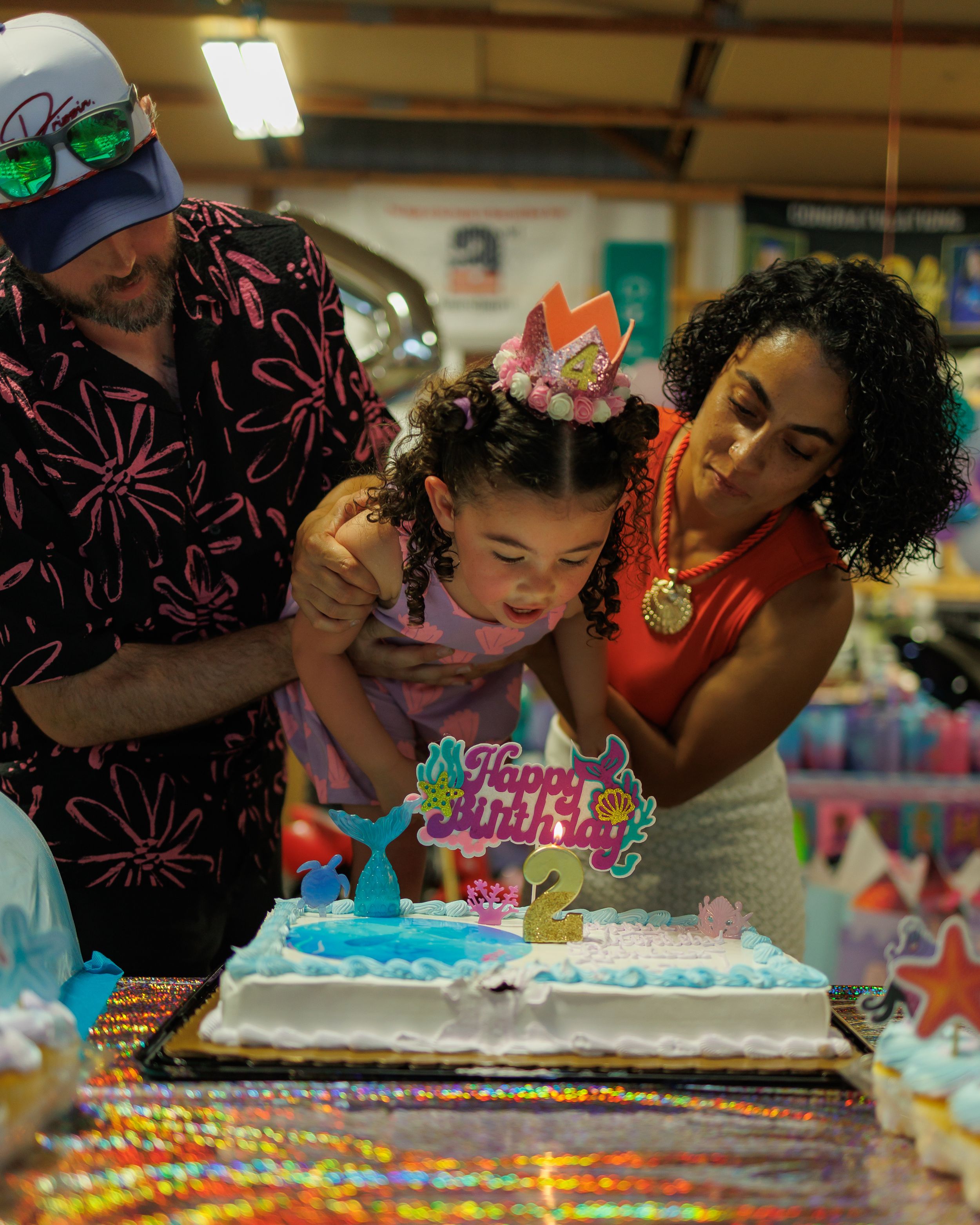 A series of photos showing someone blowing out birthday candles on a decorated cake with colorful frosting.