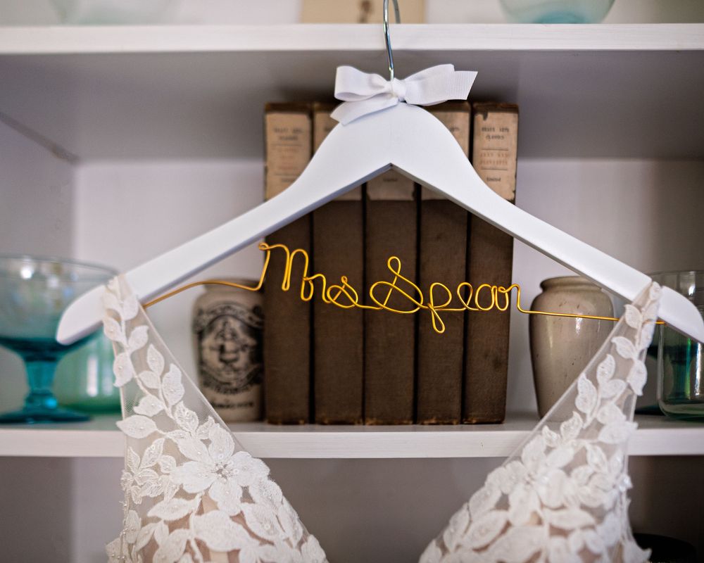 White paper origami cranes with ribbons displayed on rustic wooden shelves against a white wall.