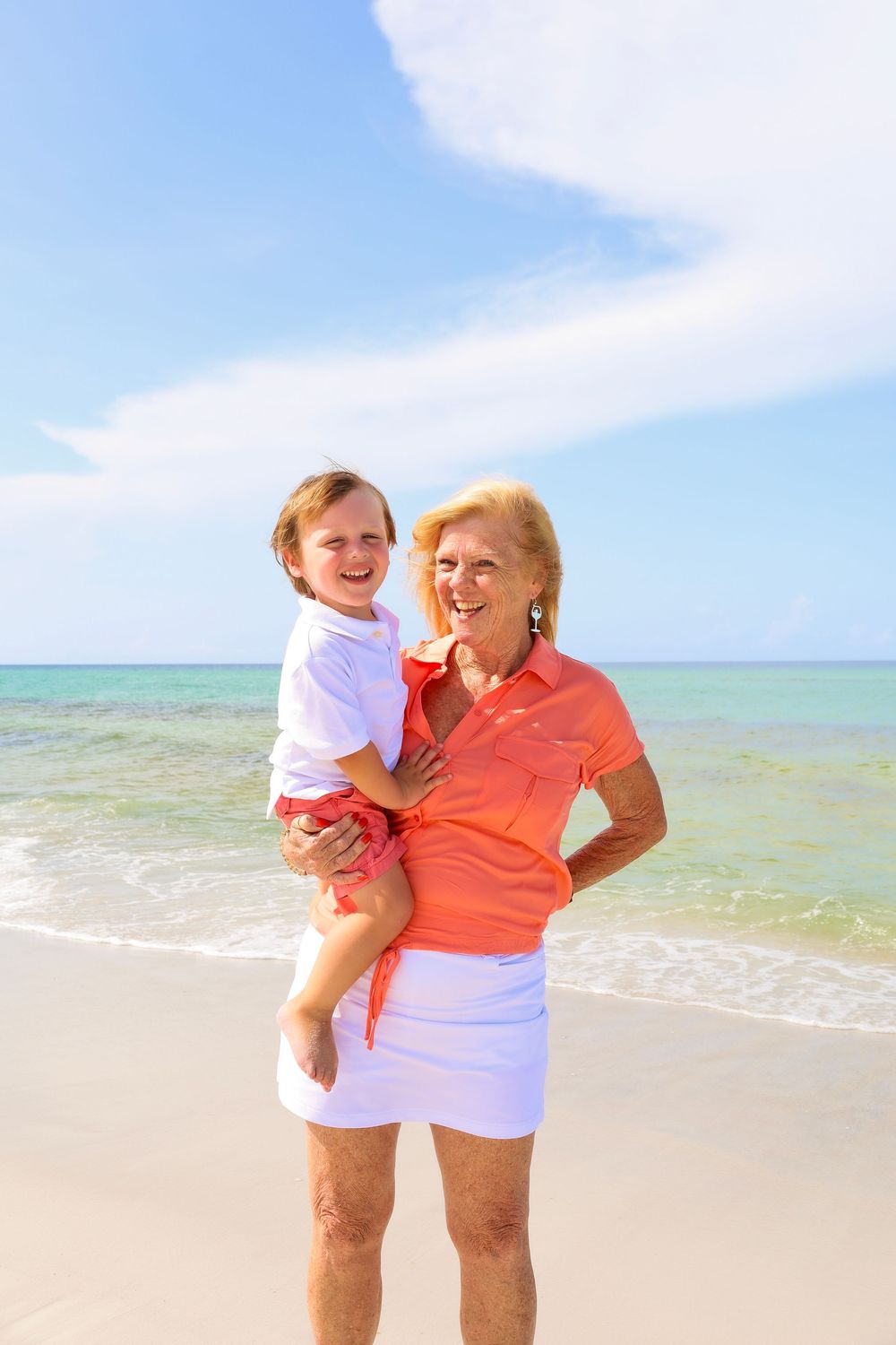 Two people sharing a joyful moment together on a beautiful tropical beach with crystal clear waters.